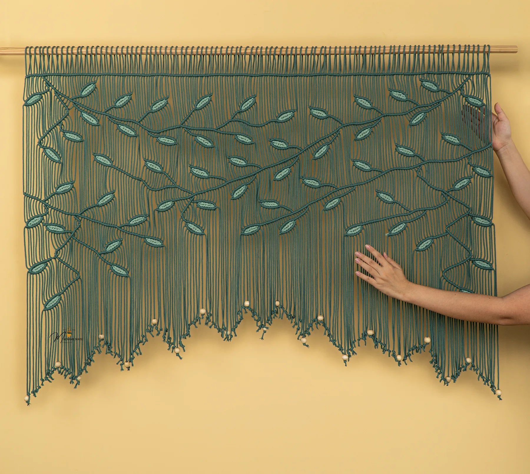Handmade beaded curtain with leaf pattern on a yellow background