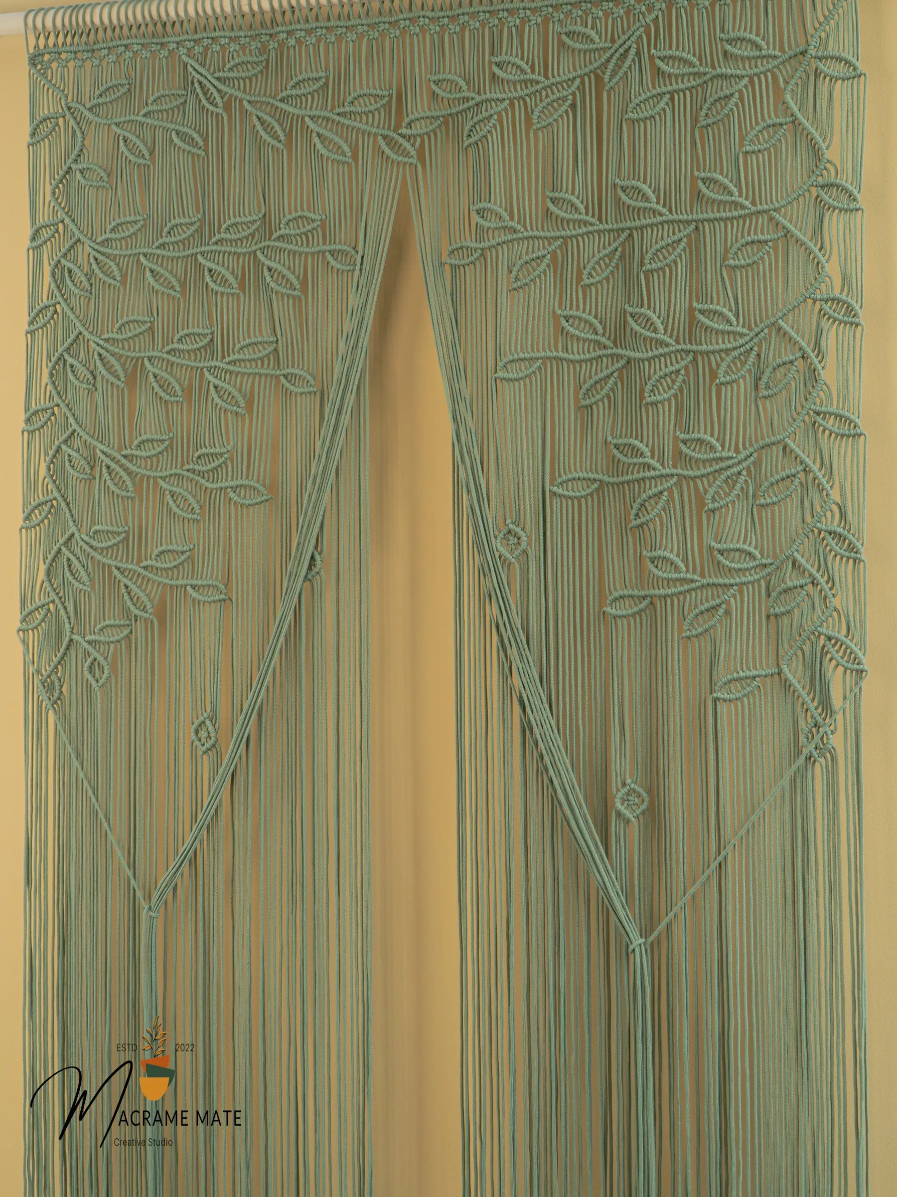 Decorative green beaded curtain with leaf pattern on a beige background