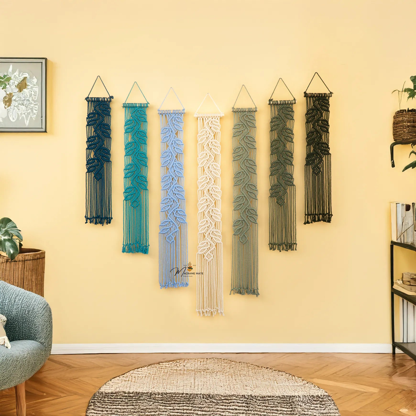 Decorative wall hangings on a yellow wall with a chair and plant in the foreground.