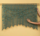 Handmade beaded curtain with leaf pattern on a yellow background
