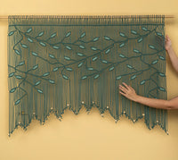 Handmade beaded curtain with leaf pattern on a yellow background