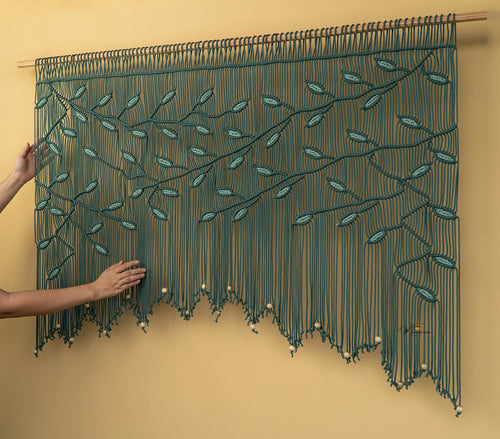 Textile art piece with leaf patterns on a beige background