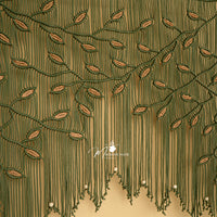 Close-up of a green embroidered fabric with a brand logo in the corner.