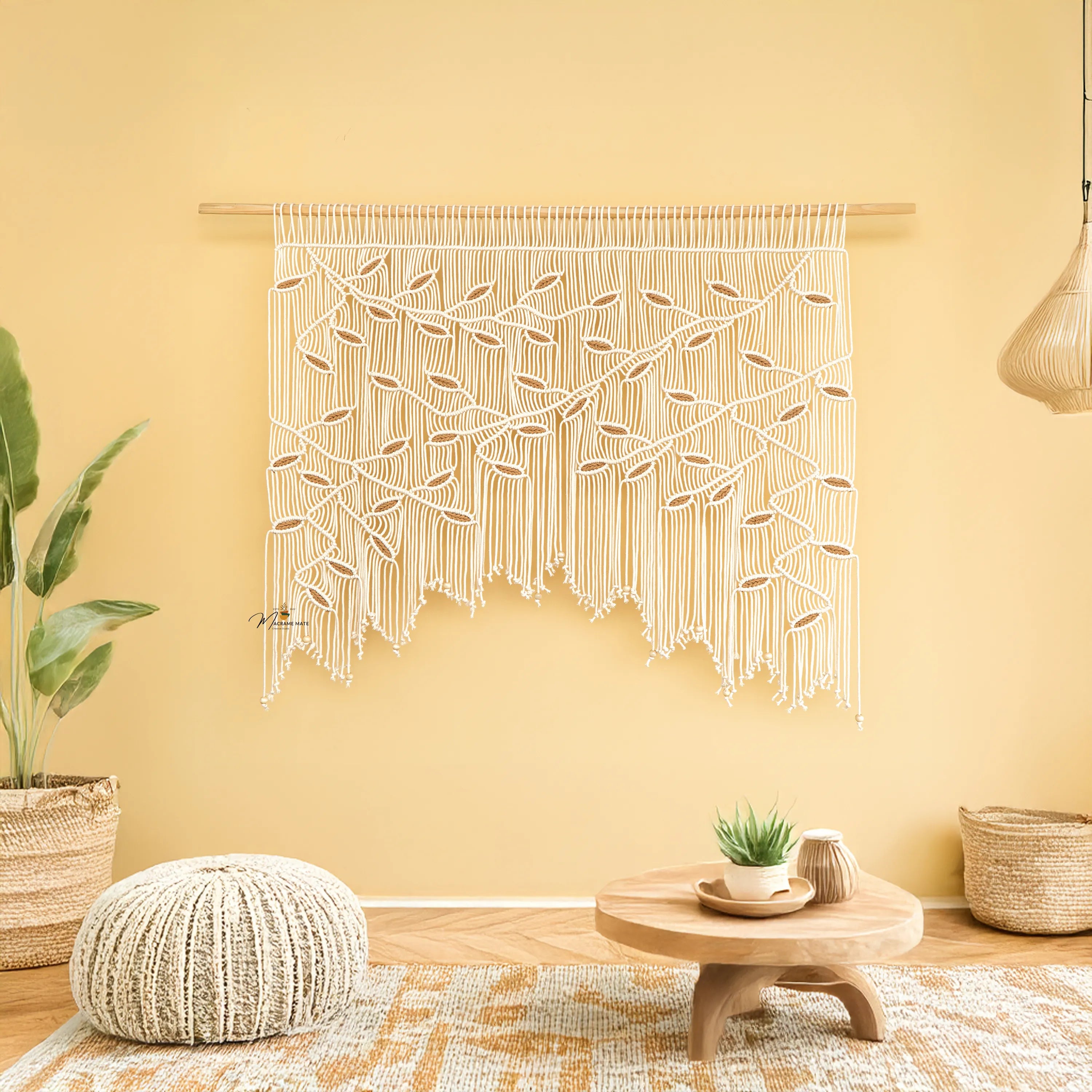 Macrame wall hanging on a yellow wall with a wooden coffee table and plants in a room.