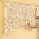 Decorative curtain with macrame design on a beige wall