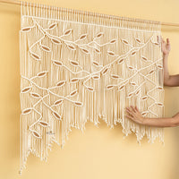 Decorative curtain with macrame design on a beige wall