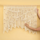 Macrame wall hanging with a geometric pattern on a yellow background