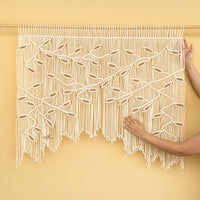 Macrame wall hanging with a geometric pattern on a yellow background