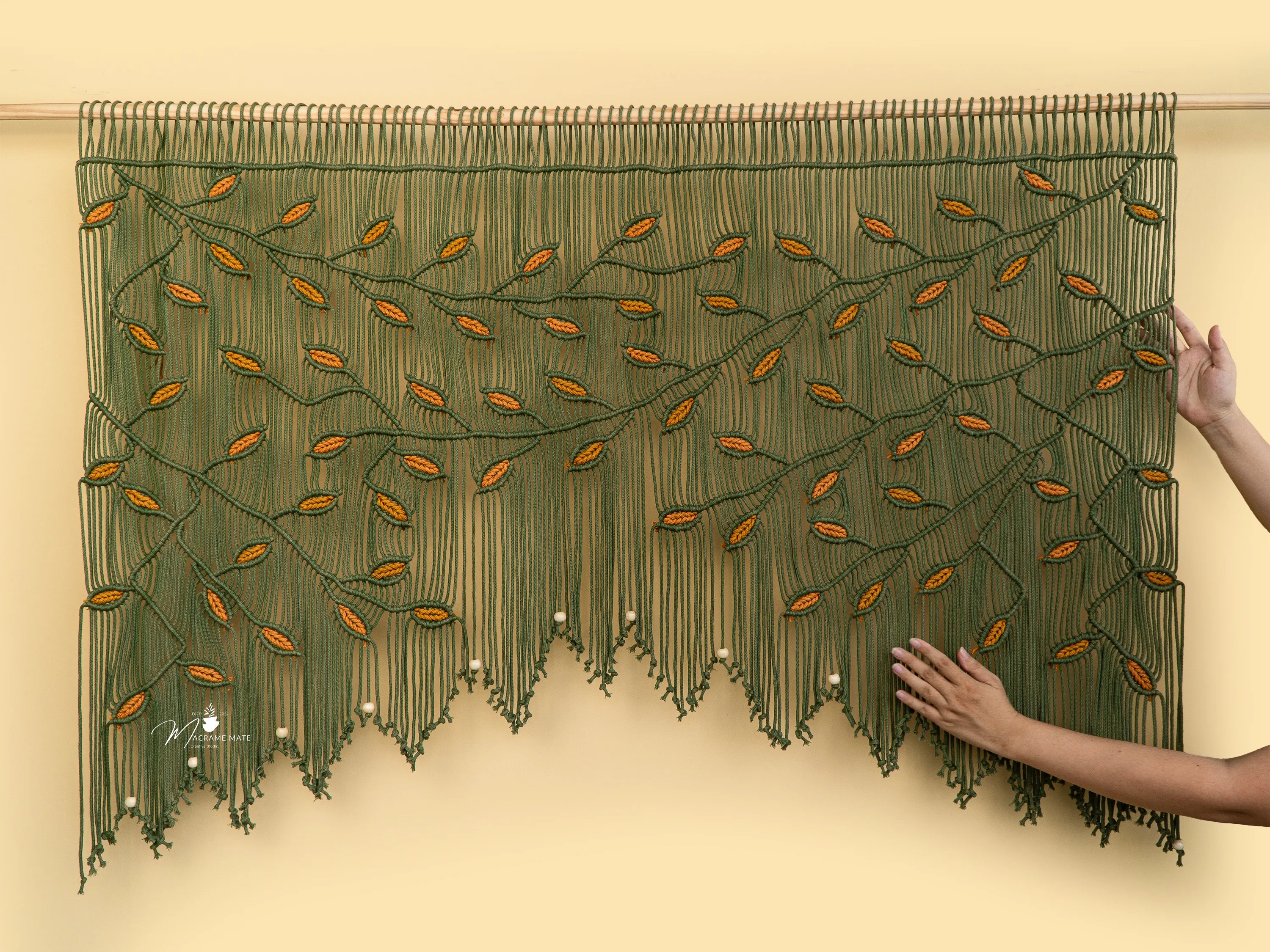 Decorative green and orange beaded curtain on a beige wall.
