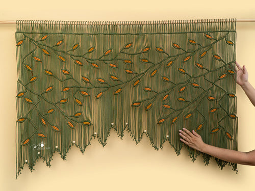Decorative green and orange beaded curtain on a beige wall.