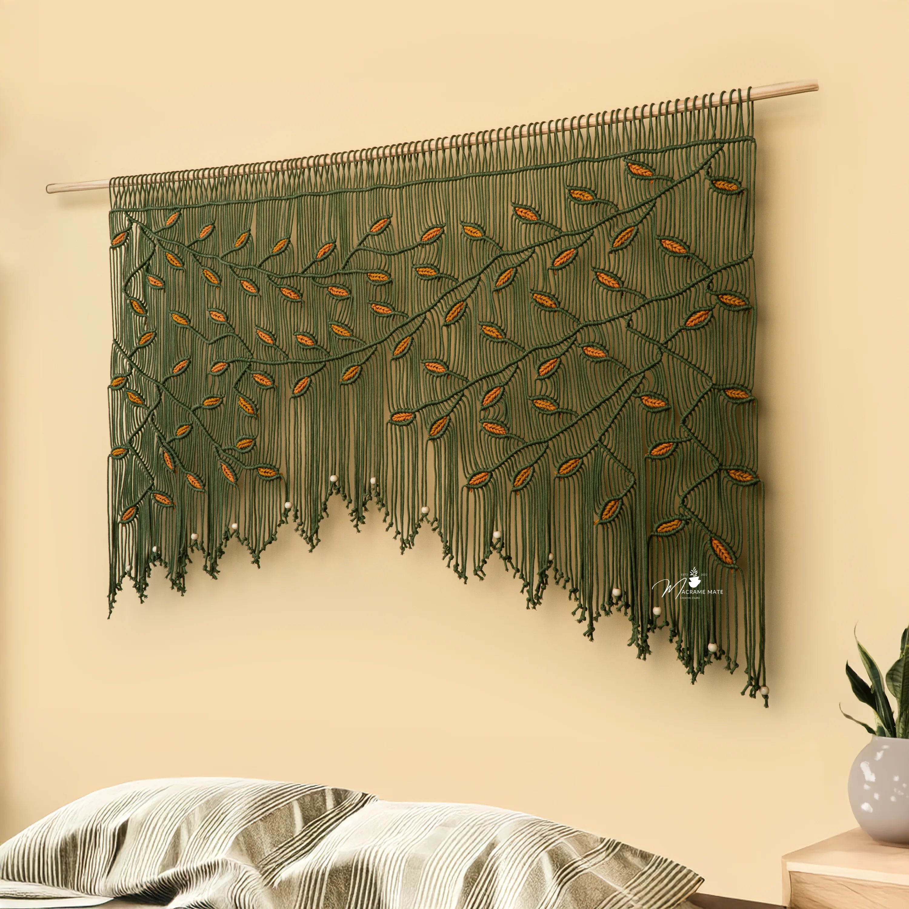 Decorative wall hanging with leaf pattern on a beige wall