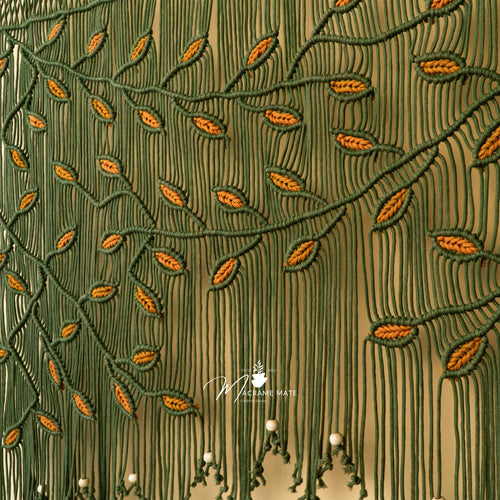 Close-up of embroidered fabric with green and orange pattern, featuring a brand logo.