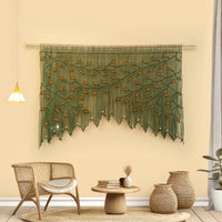Decorative wall hanging with green leaves in a living room setting.