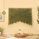 Decorative wall hanging with leaf pattern in a room with a coffee table and plants.