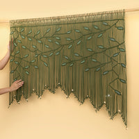 Green beaded curtain with leaf patterns on a beige wall