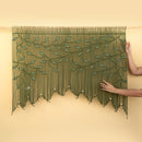 Decorative green beaded curtain with leaf patterns on a beige wall.