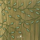Textured fabric with embroidered green leaves on a brown background, featuring the brand 'Magazine Mate'.