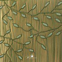 Textured fabric with embroidered green leaves on a brown background, featuring the brand 'Magazine Mate'.