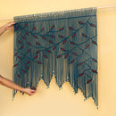 Handmade woven textile with red accents held by a person against a beige background