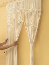 Decorative string curtain with leaf pattern against a yellow wall