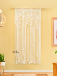 String art wall decoration on a yellow wall with a framed picture and plants.