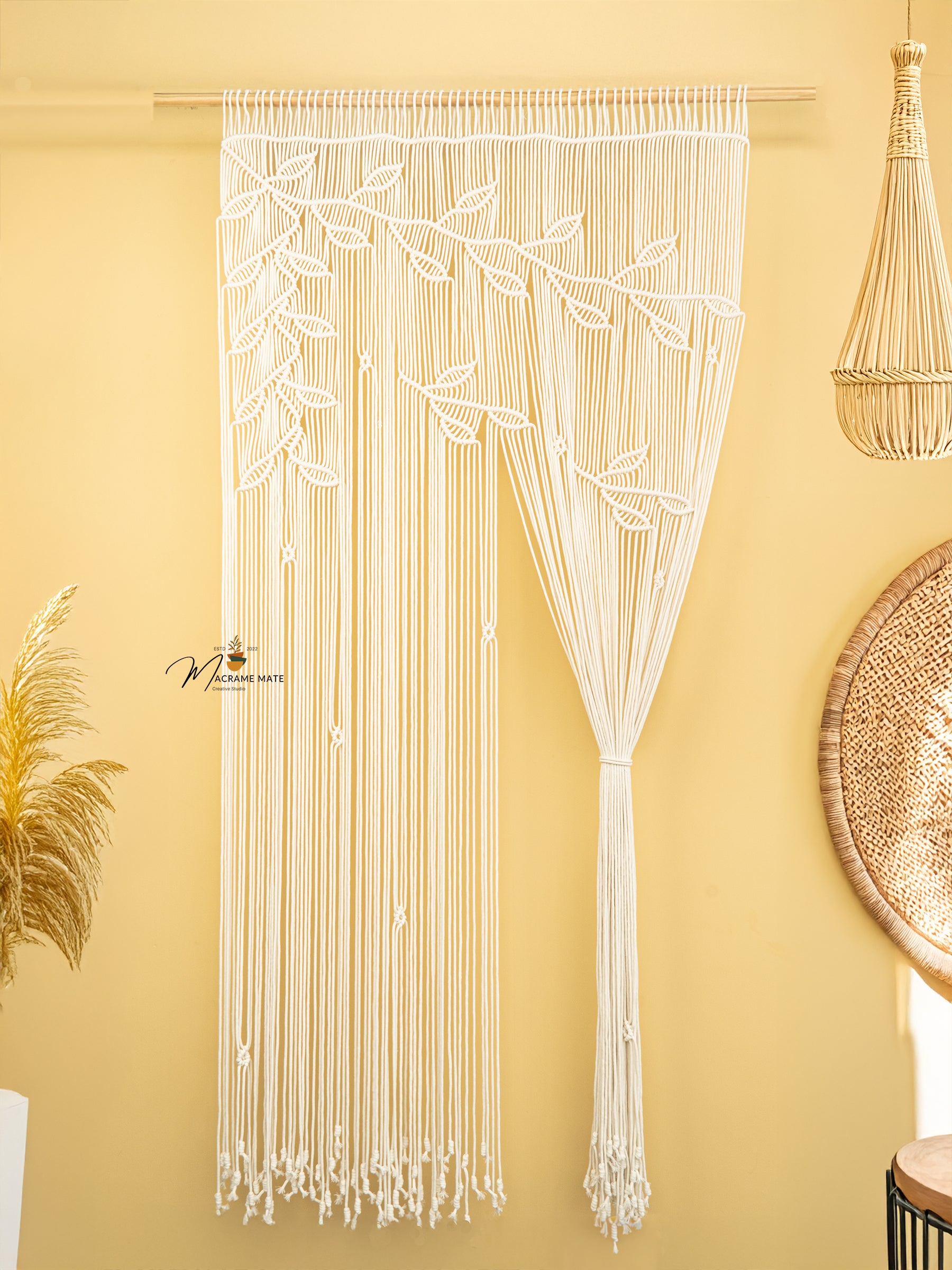 Macrame string art with leaf patterns on a yellow wall