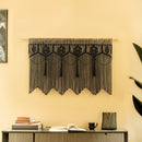 Decorative black lace curtain hanging on a yellow wall with a shelf below.