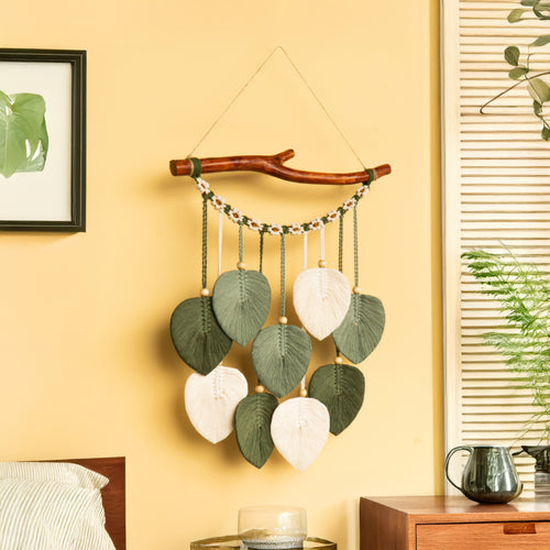 Decorative wall hanging with leaves on a yellow wall