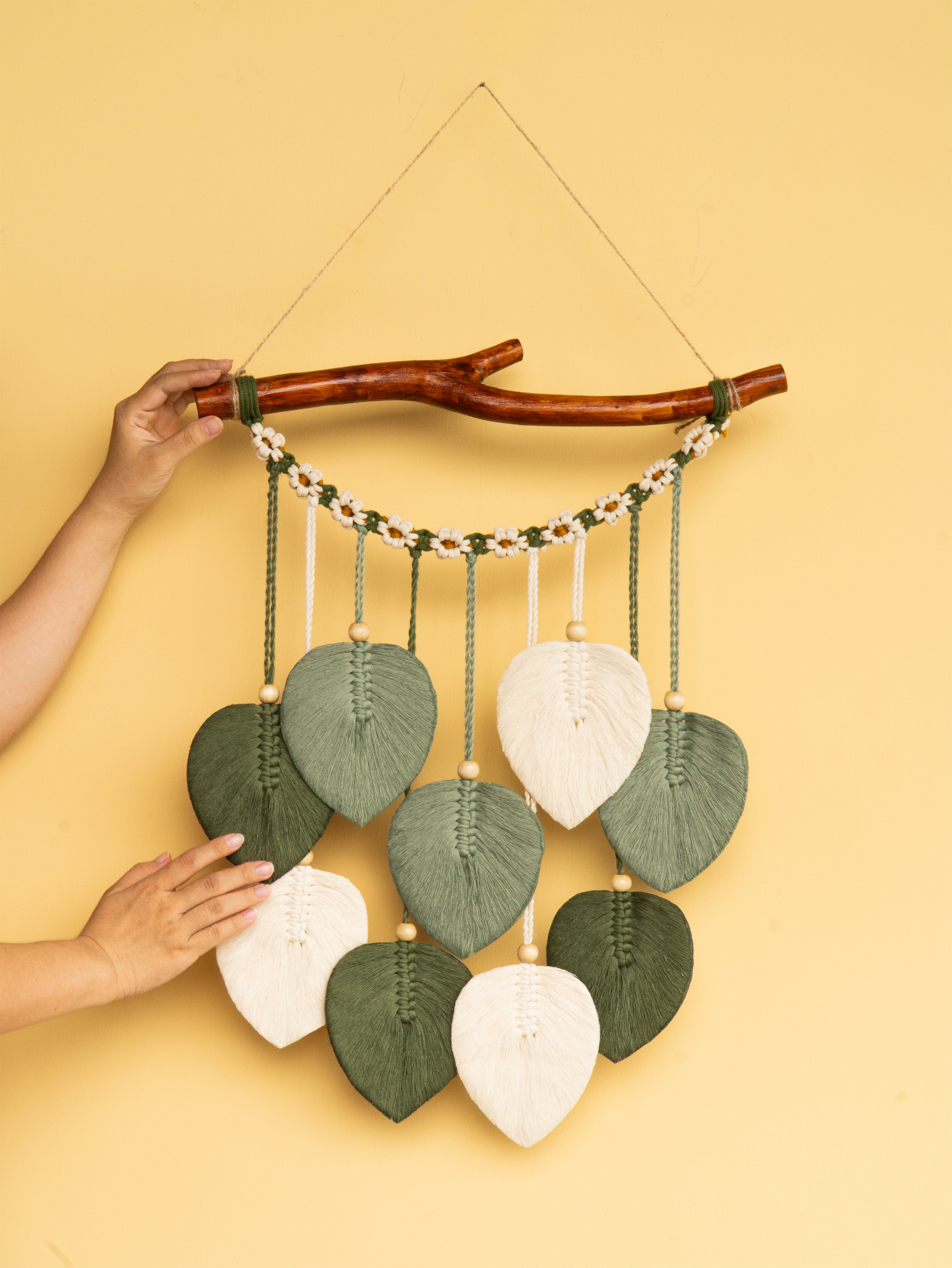 Decorative wall hanging with leaf-shaped leaves on a yellow background