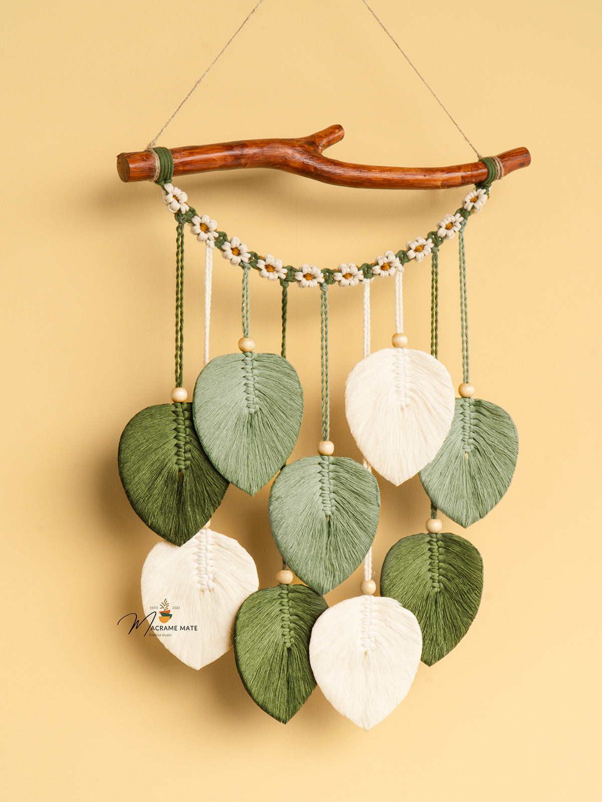 Decorative wall hanging with leaf-shaped ornaments on a beige background