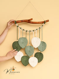 Decorative wall hanging with leaf-shaped beads on a beige background, featuring the brand 'Macrame Mate'.
