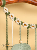 Decorative swing with floral design and wooden handle on a beige background