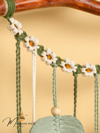 Decorative swing with floral design and wooden handle on a beige background