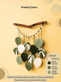 Decorative wall hanging with leaves on a branch against a beige background