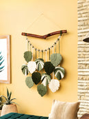 Decorative wall hanging with leaf-like elements on a yellow wall