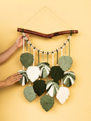 Decorative wall hanging with leaf-shaped leaves on a yellow background
