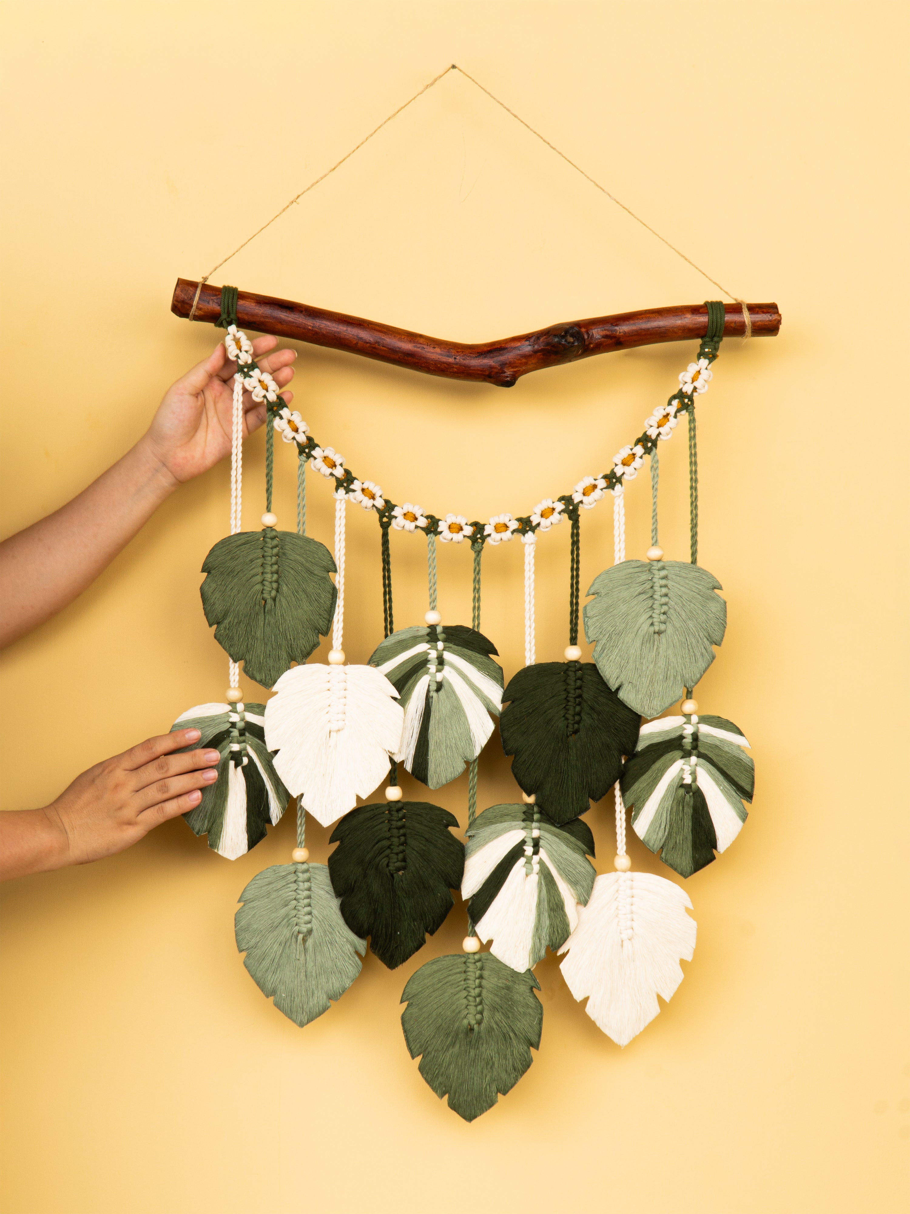Decorative wall hanging with leaf-shaped leaves on a yellow background