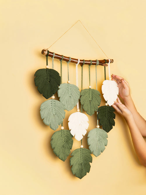 Wall hanging with leaf-shaped decorations on a yellow background