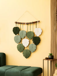 Decorative wall hanging with leaf-shaped leaves on a yellow wall.