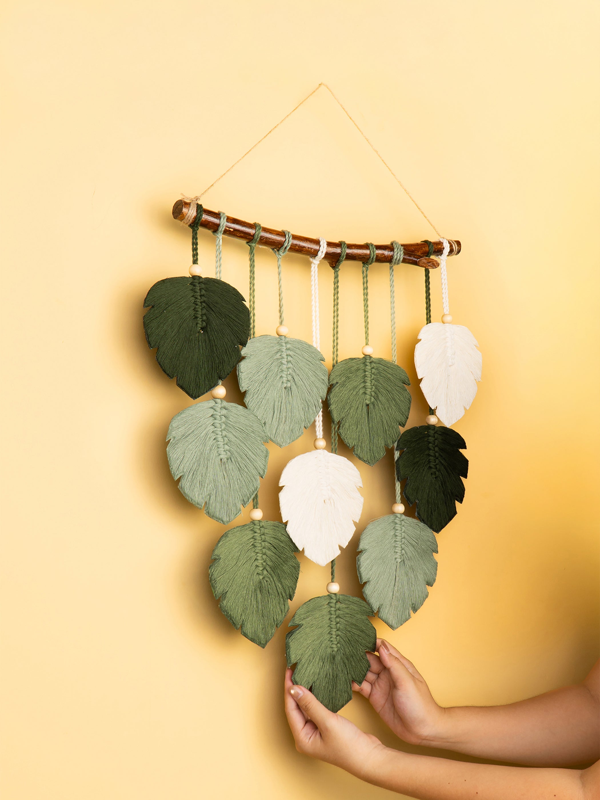 Decorative wall hanging with leaf-shaped leaves on a yellow background