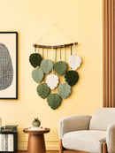 Decorative wall hanging with leaf-shaped pieces in a living room setting.