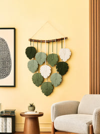 Decorative wall hanging with leaf-shaped pieces in a living room setting.