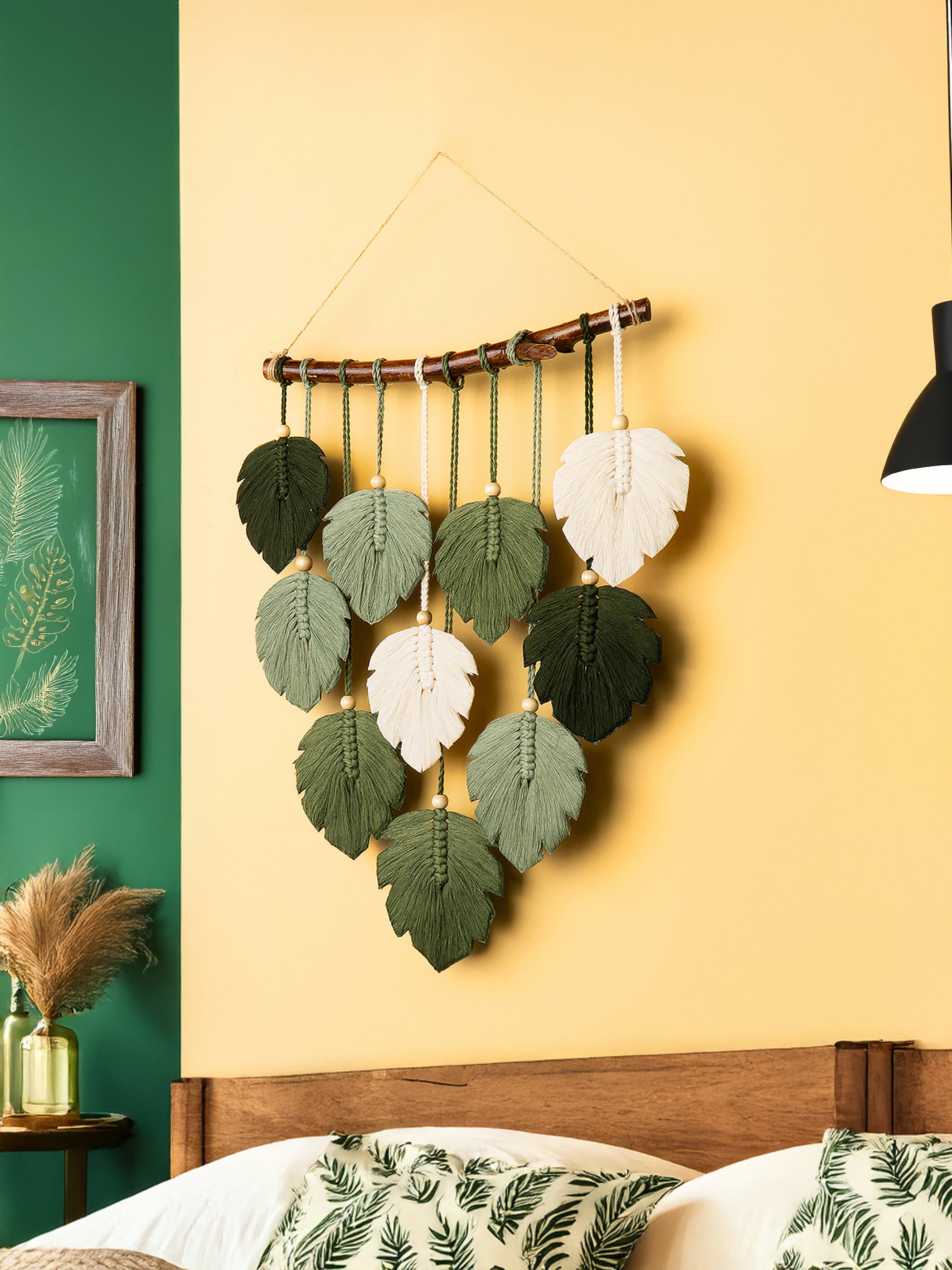 Decorative wall hanging with leaf patterns on a yellow wall.