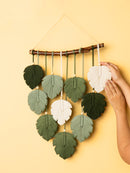 Decorative wall hanging with leaf-shaped ornaments on a yellow background