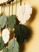 Decorative wall hanging with leaf-shaped tassels on a gold background