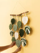 Decorative wall hanging with leaf-shaped leaves on a yellow background