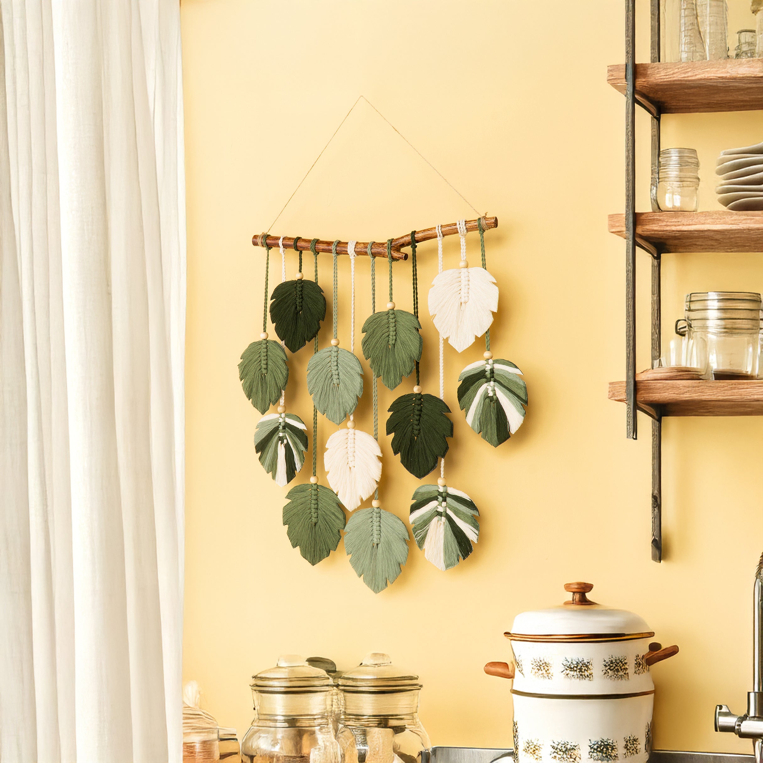 Decorative wall hanging with leaf-shaped elements on a yellow wall.