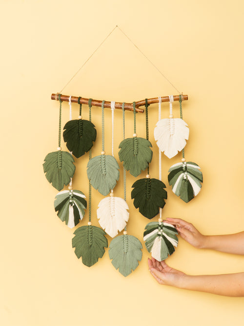 Decorative wall hanging with leaf-shaped ornaments on a yellow background