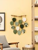 Decorative wall hanging with leaf-shaped pieces in a living room setting.