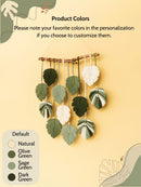 Decorative wall hanging with leaf-shaped ornaments on a yellow background